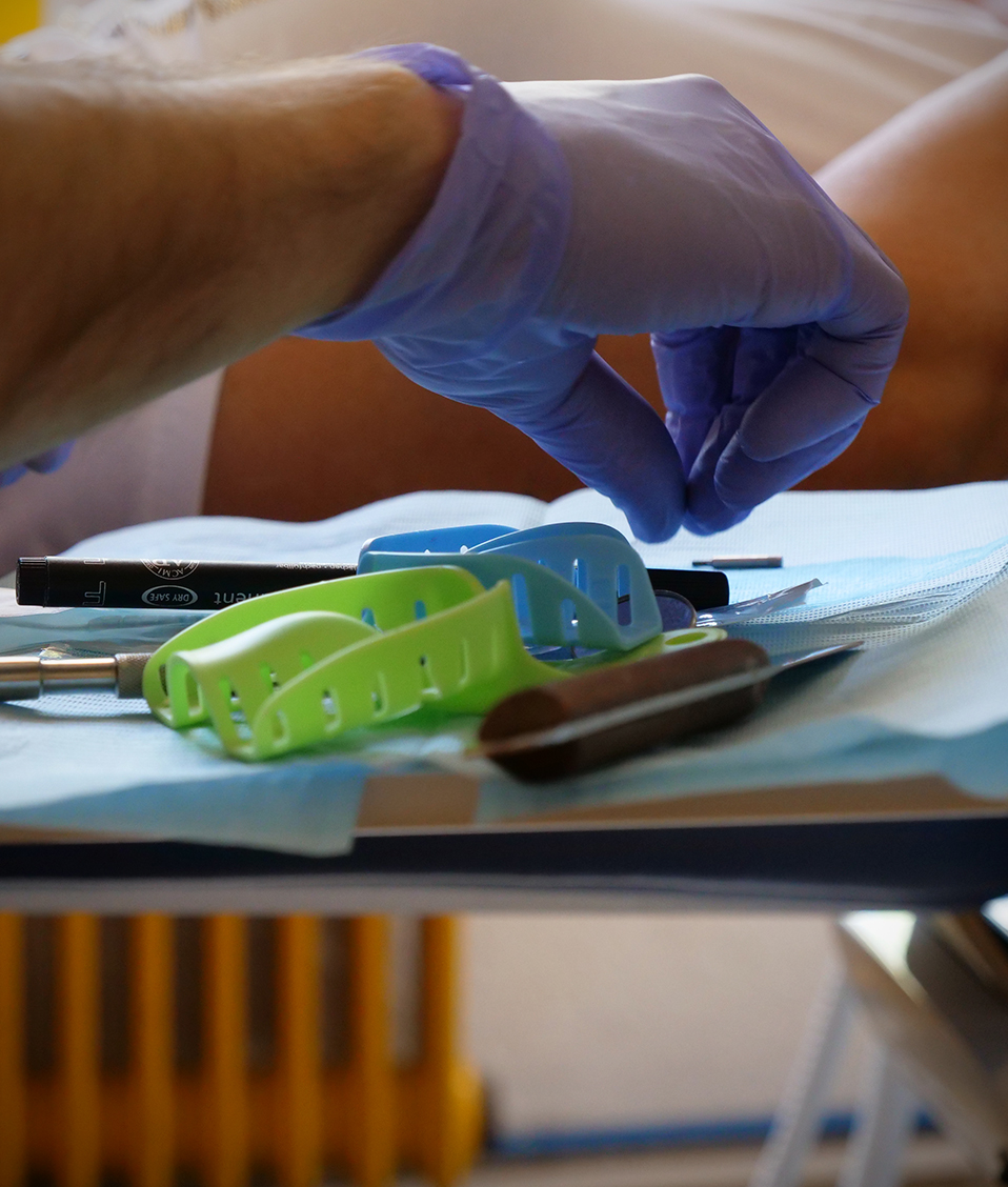 Una mano cogiendo instrumentos dentales de la bandeja de un sillón dental de la Facultad de odontología