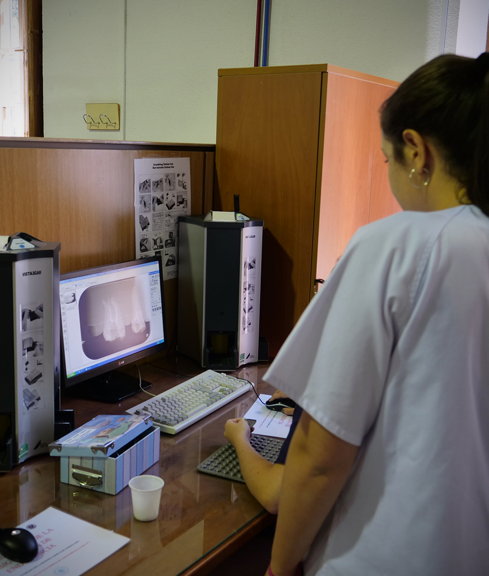 Estudiantes de la Facultad de Odontología viendo en la pantalla de un ordenador una radiografía de unos dientes
