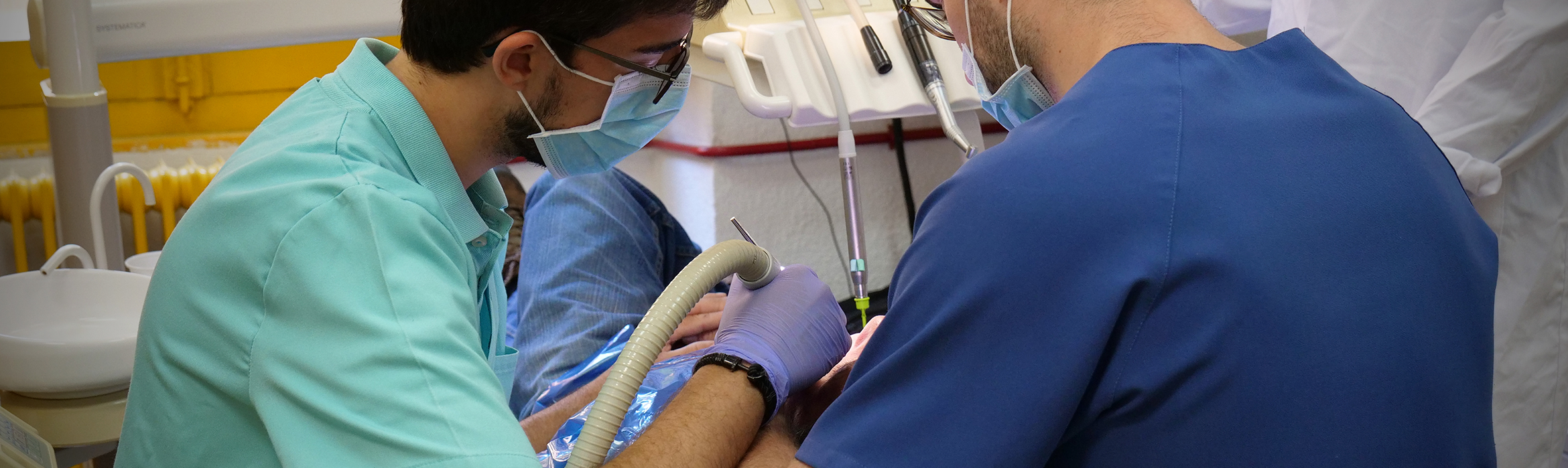 Varios estudiantes de la Facultad de Odontología, realizan un ejercicio práctico con un paciente real.