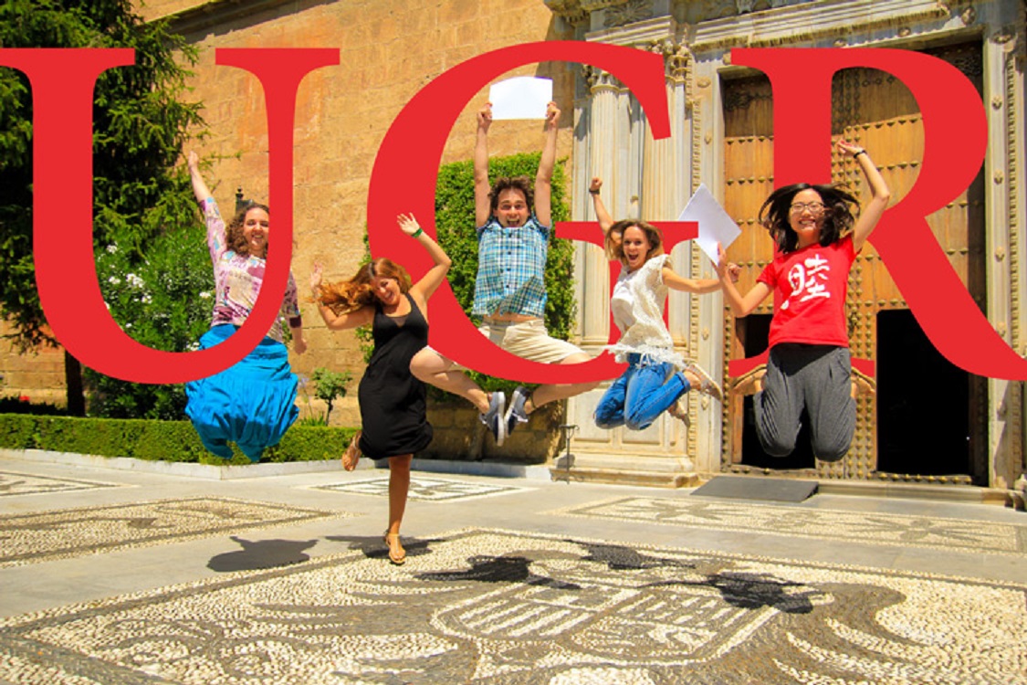 Estudiantes UGR saltando con letras en rojo